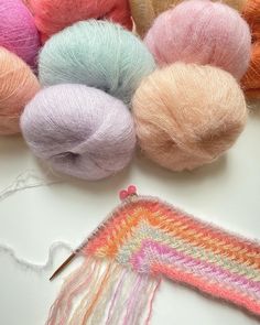 several skeins of yarn are sitting next to each other on a white surface