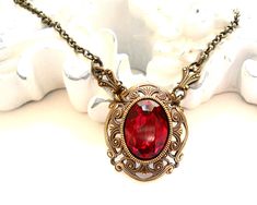 Beautiful victorian style pendant necklace made of a lovely oxidized brass filigree cabochon base, American made, and a vintage ruby red rhinestone cabochon. The size of the cabochon is 13 x 18 mm. The necklength is approximately 49 cm. (19.3 inches) For more jewelry please visit our shop: http://www.minouc.etsy.com For combined shipping please contact us. We also combine shipping with our other Etsy shop where we sell vintage fabrics and finds from Holland and France: http://www.minoucbrocante. Victorian Brass Necklace For Valentine's Day, Victorian Antique Gold Necklaces For Valentine's Day, Antique Gold Oval Filigree Necklace, Victorian Antique Gold Necklace For Valentine's Day, Elegant Oval Pendant Necklace With Antique Finish, Victorian Red Jewelry With Vintage Charm, Victorian Ruby Pendant Jewelry, Red Ruby Victorian Necklace, Red Oval Victorian Necklace