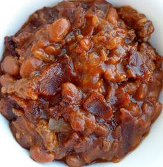 a white bowl filled with beans and meat