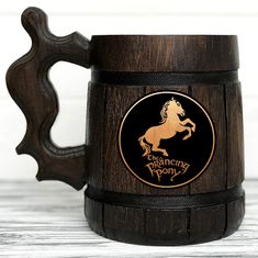 a wooden beer mug with a golden horse on it's side and the words, the dancing pony