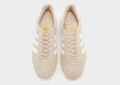 Lace up in a legendary style with these men's Gazelle trainers from adidas Originals. In a JD-exclusive Magic Beige colourway, these kicks have a soft suede upper with the iconic T-toe cap for lasting wear. They feature a lace-up closure with light padding around the ankle collar for a locked-in fit, and sit atop a streamlined midsole with soft cushioning underfoot. With a tough rubber outsole for grippy traction, they're finished with adidas' iconic 3-Stripes to the sidewalls with a Gazelle wordmark. Signed off with the Trefoil logo throughout. | IH3818 Brown Adidas, Adidas Originals Gazelle, Jd Sports, Soft Suede, Adidas Originals, Stripes, Lace Up, Adidas, Collar