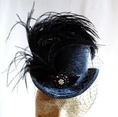 This gorgeous lady's mini top hat is covered with amazing, shiny grey velvet. It is adorned with black satin ribbon,one stunningly luscious black ostrich plum and a glorious rhinestone button (with three different tones of crystals). The whole is complete with delicate birdcage veil in black.For sparkling striking appearances! Measurements : height 3.5 inches( 9 cm ),without the feather front to back 7.5 inches ( 19 cm ) side to side 7 inches ( 18 cm ) This mini top hat is fully lined with satin Steampunk Ornaments, Victorian Burlesque, Hat With Veil, Jeweled Bouquet, Bridal Fascinator, Mini Hat, Goth Corset, Satin Noir, Halloween 2014