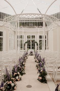 an outdoor ceremony setup with white chairs and flowers