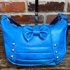 Super Cute And Goes With Everything. A Beautiful Blue With Studs And A Bow Centerpiece. Lightweight With 1 Interior Zipper Pocket. Perfect For Girls Night Out Or A Day Of Shopping. Measurements: L12/H8/W4 Chic Blue Satchel With Zipper Closure, Blue Crossbody Satchel With Zipper Pocket, Blue Satchel With Silver-tone Hardware And Double Handle, Michael Kors Handbags Black, Fendi Strap You, Blue Leather-handled Crossbody Satchel, Foldover Bag, Brown Crossbody Purse, Light Blue Leather Bag With Silver-tone Hardware