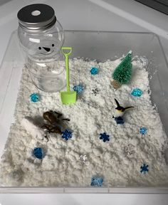 a snowman made out of sand and plastic toys