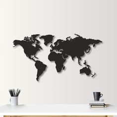 a black and white world map is on the wall above a desk with a coffee cup