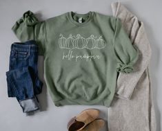 Hello Pumpkin Olive Green Fall Crewneck Embrace the cozy charm of autumn with our 'Hello Pumpkin' Olive Green Fall Crewneck. Crafted for comfort and style, this crewneck is a perfect addition to your fall wardrobe. Key Features: Soft Cotton Blend: Made from Hanes brand crewneck sweatshirt, 50% polyester 50 % cotton Charming Design: Features 'Hello Pumpkin' in a stylish and inviting font, perfect for the fall season. Versatile Wear: Ideal for casual outings, pumpkin patches, or enjoying crisp fal Soft-washed Sweater For Fall, Soft-washed Fall Sweater, Cotton Sweater For Fall, Cozy Soft-washed Sweater For Fall, Green Comfortable Fit Sweatshirt For Fall, Fall Crew Neck Sweater With Comfortable Fit, Comfortable Long Sleeve Fall Sweater, Comfortable Long Sleeve Sweater For Fall, Green Sweatshirt For Fall