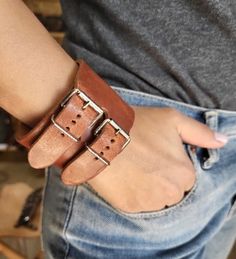 {Constructor} : Handcrafted by me Vasilis, from top quality leather wrap bracelet for arms. {Durable Genuine Leather}: It fastens with an engraved 2 small buckles with holes. This piece looks beautiful if you wear it solo. {Dimension}:  * Leather comes in brown,black,dark brown 24.5cm(L)x5.0cm(W) weight: 0.100gr {Quantity Structure}: This plain  bracelet is handmade in Greece, has a soft rock/retro/punk style and it is look elegant for all type of people. {Good Helper}: Practical gift to yourself, friends,  they will love it. Also we could give for gift for any occasion her birthday, for your Boss ,New Year, Valentine's Day, Mother's Day, Thanksgiving Day, Christmas and other holidays,  The shipping costs are very low for any country so ask me before to estimate delivery days in your count Everyday Leather Wristband With Bracelet Strap, Leather Strap Cuff Bracelet For Everyday, Adjustable Brown Leather Bracelet With Belt Detail, Adjustable Brown Leather Belt Bracelet, Everyday Double Band Leather Bracelet, Adjustable Leather Cuff Bracelet With Bracelet Strap, Adjustable Double Band Leather Bracelet, Leather Double Band Bracelet With Leather Strap, Adjustable Leather Bracelet With Custom Hardware