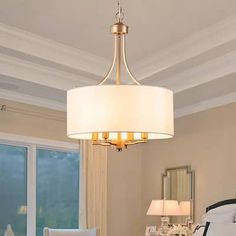 a chandelier hanging from the ceiling in a room with white furniture and windows