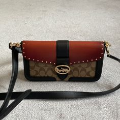 Nwot Coach Clutch. It Is 10 Inches Across And 51/2 Inches Down. It Has An Ombr Orange Leather Top Studded In Gold. Classic Brown Pattern With Black Accent Snap Close Inside Bronze Suede With Two Sections Beautifully Designed. Never Used Luxury Brown Shoulder Bag With Snap Closure, Brown Shoulder Bag With Gunmetal Hardware For Evening, Coach Clutch, Coach Poppy, Black Wristlet, Brown Pattern, Classic Brown, Clutch Pouch, Orange Leather