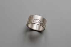 A ring for you, who loves the sea. The waves design is imprinted individually for every ring, making every ring a unique piece of jewelry. With its simple, yet elegant design it is a perfect unisex ring suitable for everyone. Minimalist Sterling Silver Wavy Ring, Wide Silver Band, Waves Design, Ring Making, Unisex Ring, Wave Design, Silver Band Ring, Design Simple, Silver Band