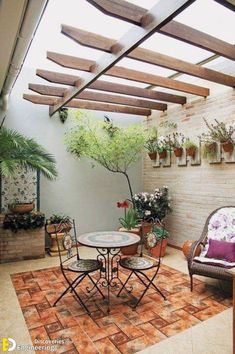 an outdoor patio with potted plants on the wall and table in the center, surrounded by wicker chairs