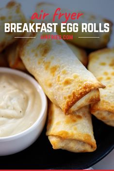 an egg roll on a plate with dipping sauce in the middle and text overlay reading air fryer breakfast egg rolls