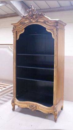 an antique wooden bookcase with black glass doors