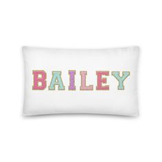 a white pillow with the word bailey printed on it in multicolored letters and dots