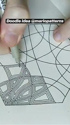 someone is drawing on paper with a pen