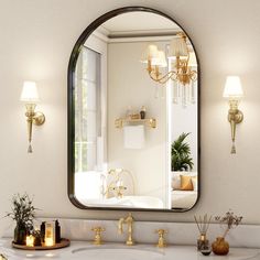 a bathroom sink with a mirror above it and candles on the counter next to it