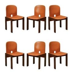 six orange chairs are arranged in a row