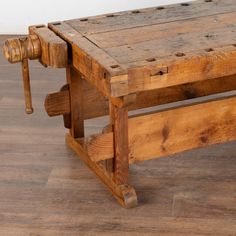 an old wooden bench with wheels on the top and bottom, sitting on a hard wood floor