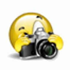 a camera with a yellow smiley face on it's side and the lens up