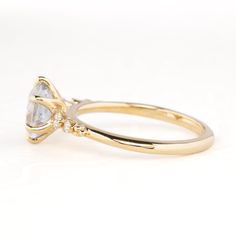 a yellow gold ring with a pear shaped diamond on the side, and two smaller pear shaped diamonds at the top