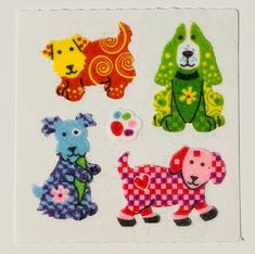 four different colored dogs are on a white square sticker with black and red checkered squares