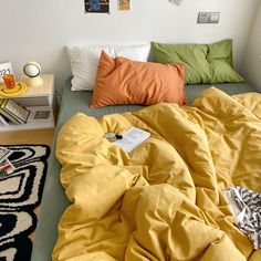 an unmade bed with yellow sheets and pillows on top of it in a bedroom