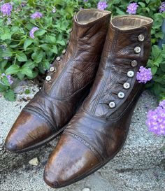 One of many antique shoes we have for sale! A pair of Antique (c1900-1910s) Mens button up boots/shoes. Can be unisex. Deep caramel Brown color in a smooth leather fabric with cotton twill lining. *Refer to last photo and condition comments for notable Issues.  Size: looks like size mens 10 indicated? I wear a womens 7.5-8 and they are a little big for me (long in the toe area) but it is always best to refer to measurements when purchasing Antique shoes.  These boots tend to be more narrow than modern, please check your own width and arch carefully.  Measurements: -inner footbed measurement 10" -outer sole length-toe tip to back of the heel is 11.5" Heel height is 1" Width of sole 3.5" (widest part of the sole) Boot height 6" Arch 11.25" (around arch of foot) 7 button sets CONDITION: pre-o Antique Shoes, Button Boots, Dress Boots, Caramel Brown, Mens Button Up, Unisex Shoes, Mens Shoes Boots, Dark Brown Leather, Boots Shoes