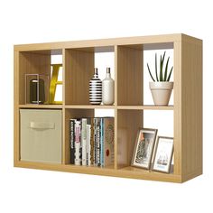 a book shelf filled with lots of books next to a potted plant and pictures