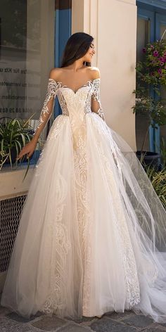 a woman in a wedding dress standing outside