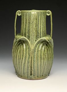 a green vase sitting on top of a table