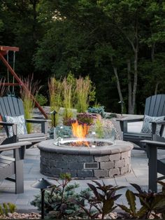 an outdoor fire pit with chairs around it