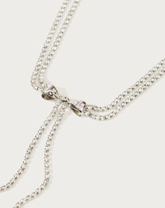 Materials: 18k platinum plated brass, cz stone Measurements: 410mm/16.1" in length, 70mm/2.8" in extension length. a captivating fusion of celestial charm and doll-inspired whimsy. This exquisite silver necklace showcases a charming bow tie droplet, its delicate strings cascading down like stardust trails. This silver Y2K x BarbieCore droplet isn't just an accessory; it's a cosmic statement piece that invites you to weave your own story amidst the stars, where the rules of style are yours to red Elegant Sterling Silver Rhinestone Necklace For Party, Glamorous Silver Rhinestone Necklace As Gift, Adjustable Sterling Silver Necklaces For Party, Adjustable Sterling Silver Party Necklace, Adjustable Sterling Silver Necklace For Party, Adjustable Sparkling Rhinestone Necklace, Adjustable Rhinestone Necklace As Gift, Elegant Dangle Rhinestone Necklace, Sparkling Rhinestone Necklace For Gift