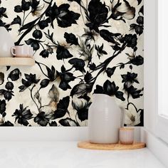 black and white wallpaper with flowers on it in a kitchen area next to a window