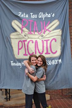 two girls hugging each other in front of a sign for piak picucic