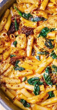 pasta with chicken, spinach and sauce in a pan