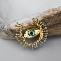 Crafted in gold-tone metal, it features a vibrant blue and white enamel eye surrounded by sparkling crystals. This unique brooch is believed to offer protection and ward off negative energy, making it a meaningful and stylish gift. What Is Included: - 1 x Evil Eye Brooch Key Features: - Bold and eye-catching design - Gold-tone metal with enamel and crystals - Represents protection and good luck - Versatile accessory for jackets, bags, or scarves At EyeSpyEvilEye, our family has dedicated over 4 Unique Handmade Gold Enamel Pin, Gold Enamel Brooch Pin, Handmade Gold Enamel Pin, Eye Brooch, Unique Brooch, Unique Jewelry Gifts, Protection Amulet, Crystal Eye, Sparkling Crystal