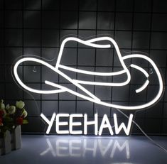 a neon sign that says yeehaw with a cowboy hat on it