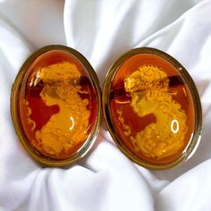 SAME DAY SHIPPING  Frozen in time, a beautiful woman sits by a pond under the light of the moon. Her delicate feet resting in the cold waters of spring nighttime. Beauty of mind incarnate. These vintage, carved amber cameo earrings oval cabochon earrings are handcrafted with solid 14k yellow gold. The hand chosen and polished amber cabochons have fabulous color and hand carvings of a womans portrait. They are approximately 30 CTTW. The glimmering gold is the perfect accentual treat to the eye. E Vintage Oval Cabochons For Formal Occasions, Vintage Yellow Gold Cabochons As Gift, Vintage Yellow Gold Cabochons For Gift, Formal Carved Earrings, Vintage Oval Gold Cabochons, Ruby Engagement Ring Gold, Estate Jewelry Rings, Vintage Gold Engagement Rings, Emerald Ring Vintage