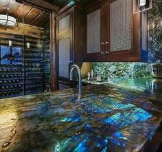 a large kitchen with marble counter tops and wine racks in the wall behind the sink