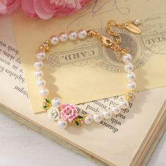 Adorn your wrist in natural elegance with the Wild Rose Pearl Bracelet. Delicate pink roses, each petal intricately engraved, entwine to form the band encasing shimmering freshwater pearls. Enamel in rich shades of green leaf and rosy floral hues brings the English countryside to mind. Light and lovely, this piece offers far more than meets the eye with its carefully crafted floral charm. Subtle and sweet, it brings beauty and delight to every occasion. DETAILS Plating: 18K Gold Materials: 18K G Adjustable Flower Jewelry With Roses, Gold Flower Bracelets With Rose Design, Adjustable Flower Shaped Rose Jewelry, Gold Floral Bracelets With Rose Design, Gold Flower Bracelet With Rose Design, Elegant Rose Colored Bracelet Jewelry, Elegant Rose-colored Bracelet Jewelry, Elegant Rose Jewelry For Mother's Day, Rose Gold Bracelet With Rose Design For Gift