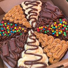 a box filled with lots of different types of cookies and desserts on top of each other