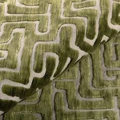 a close up view of a green and white fabric with an interesting design on it