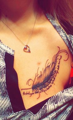 a woman's chest with a feather tattoo on her left side and words written in cursive writing