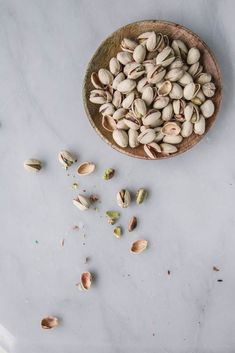 pistachios in a wooden bowl on a white table