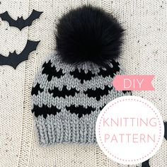 a knitted hat with a black and white pattern on it, next to bats