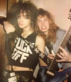 two people are posing with guitars in their hands