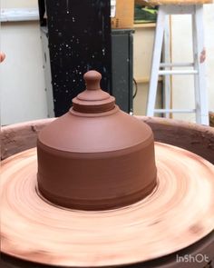 a clay pot sitting on top of a potter's wheel