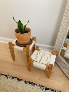 a potted plant sitting on top of a wooden chair next to a mirror and rug