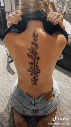 the back of a woman's body with tattoos on it